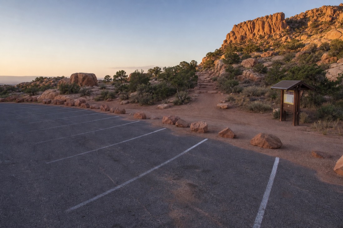 Empty parking area and trailhead near a desert overlook in early morning light