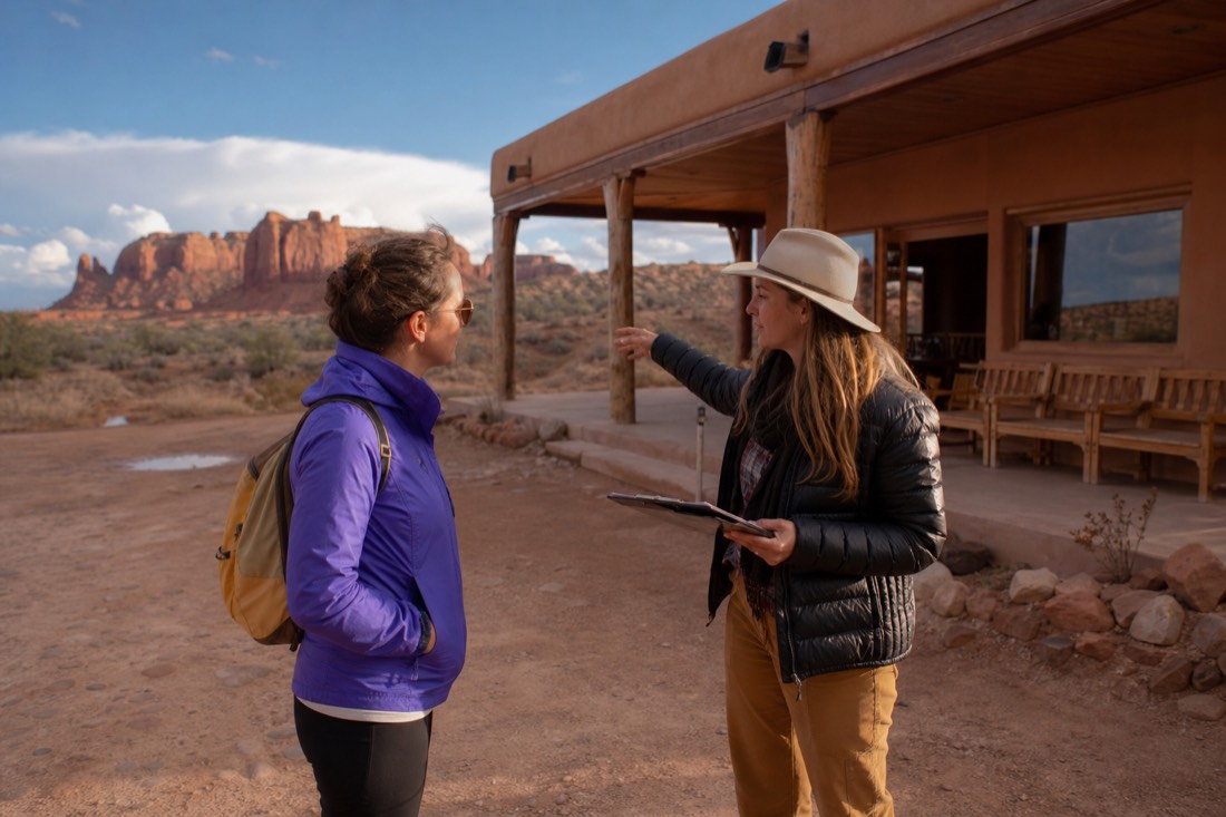 Traveler talking with a tour office employee under a clearing sky after a desert storm
