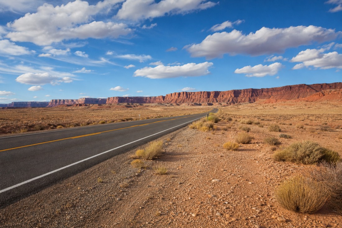 US-89 crossing open Navajo Nation high desert with distant vermilion cliffs