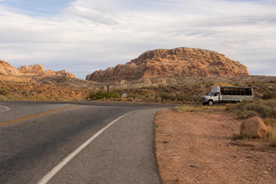 Guide's view of a desert road junction near Page with a tour truck waiting at the turn-off
