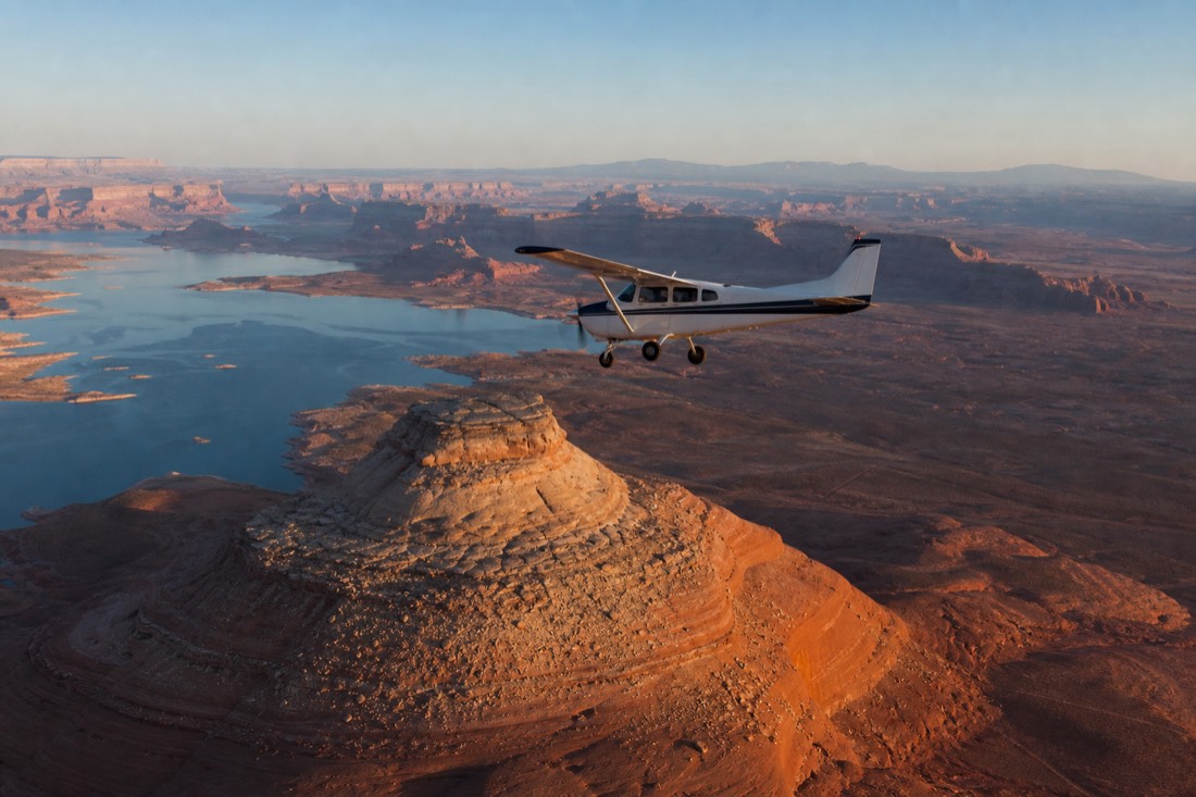Small propeller aircraft over red desert terrain near Lake Powell
