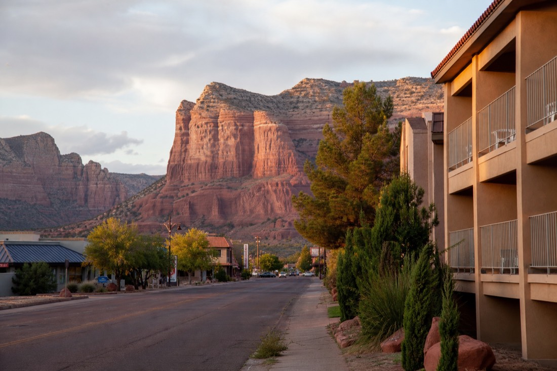 View over a small desert town street with hotels and red sandstone mesas beyond
