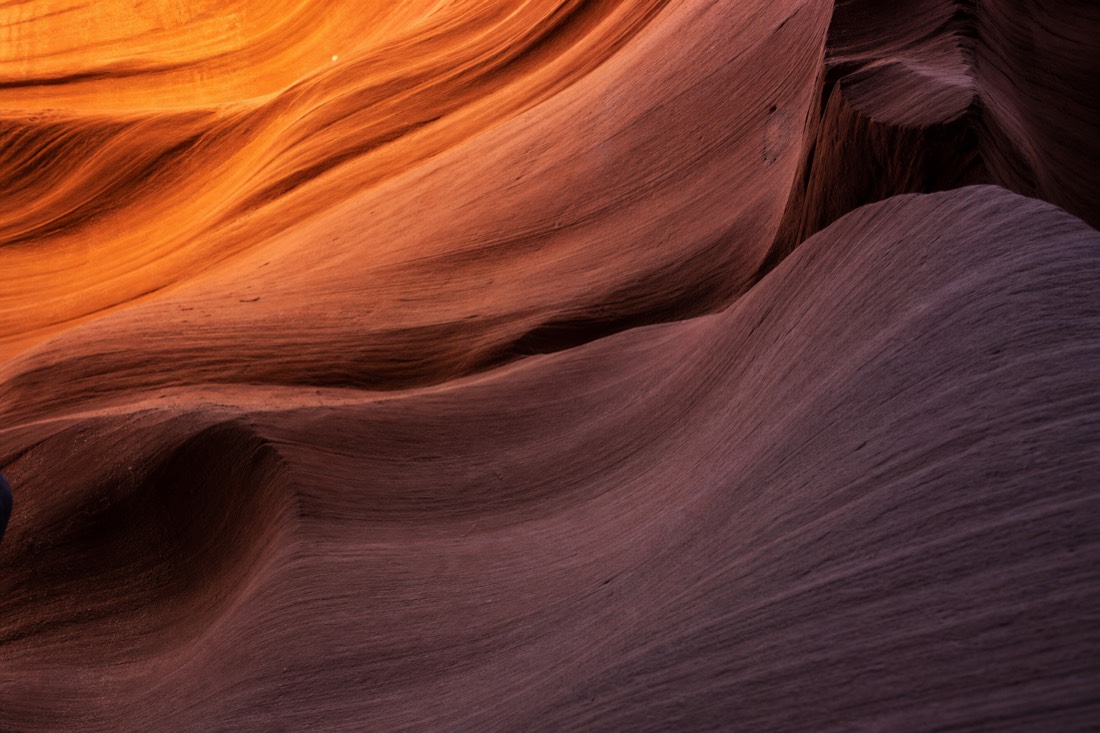 Sculpted wave-like walls of Upper Antelope Canyon rising toward a thin slit of sky